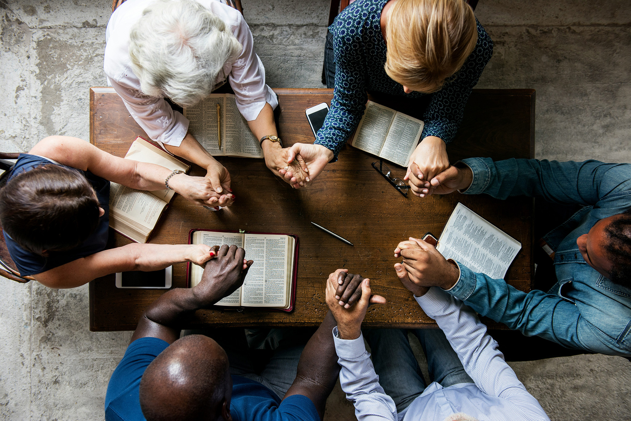 Group gathered in prayer around a table